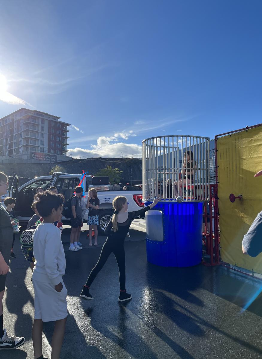 Picture of a student in a dunk tank at a school fair. 